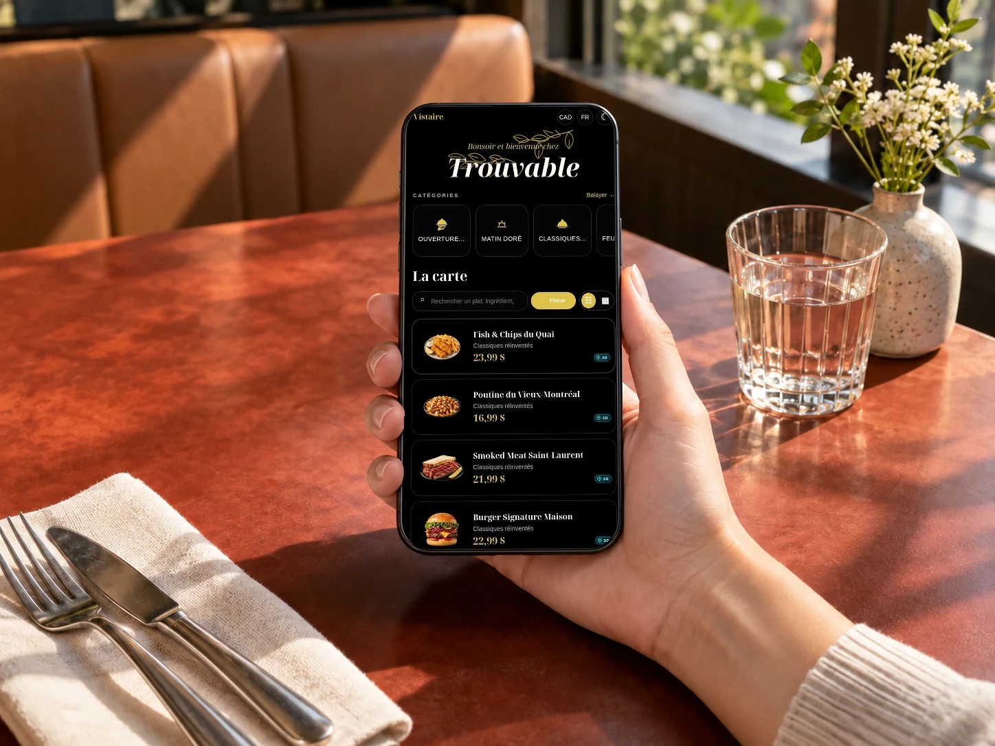 Carte Trouvable avec catégories, photos et prix, affichée sur un téléphone à table